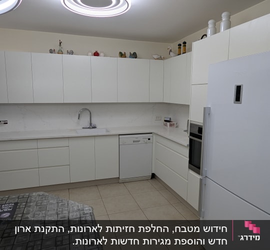 מטבח מודרני עם ארונות לבנים ומקרר גדול